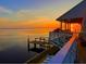 A waterfront home features a private dock, porch and amazing sunset view at 121 Augusta Ave, Palm Harbor, FL 34683