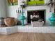 Fireplace mantel with decorative accessories, painted white brick and wood flooring at 121 Augusta Ave, Palm Harbor, FL 34683