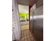 View of modern kitchen with stainless steel refrigerator and open access to the light green living room at 121 Augusta Ave, Palm Harbor, FL 34683
