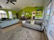 Open concept living room featuring bright green walls, multiple seating areas and a dining space at 121 Augusta Ave, Palm Harbor, FL 34683