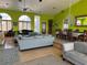 Open floor plan featuring bright green walls, wood floors, multiple seating options and dining area at 121 Augusta Ave, Palm Harbor, FL 34683