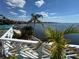 Scenic water view from the deck featuring palm trees and beautiful blue skies for a relaxing outdoor experience at 121 Augusta Ave, Palm Harbor, FL 34683