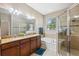 Bright bathroom featuring a granite countertop, double sinks, tub, and glass-enclosed shower at 1250 Halapa Way, Trinity, FL 34655