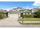 Charming single-story home featuring a manicured lawn, a two-car garage, and inviting curb appeal at 1250 Halapa Way, Trinity, FL 34655