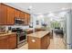 Open kitchen with wooden cabinets, granite countertops, and stainless steel appliances at 1250 Halapa Way, Trinity, FL 34655