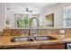 Close-up of a stainless steel sink with granite countertops and views to the living room at 1250 Halapa Way, Trinity, FL 34655