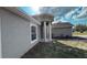 Angled view of the home's exterior highlighting the stucco finish and covered entrance at 13066 Painted Bunting Ave, Weeki Wachee, FL 34614