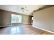 Open concept living room boasts natural light, ceiling fan, and sleek hardwood flooring at 13066 Painted Bunting Ave, Weeki Wachee, FL 34614