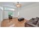 Bright living room with hardwood floors, large windows, and comfortable leather furniture at 1615 Cortleigh Dr, New Port Richey, FL 34655
