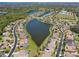 Aerial view of homes surrounding a community lake, showcasing a neighborhood with mature trees at 1709 Nodding Thistle Dr, New Port Richey, FL 34655