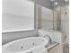 Bright bathroom featuring an oval soaking tub, glass shower, white subway tile and natural light from the window at 1709 Nodding Thistle Dr, New Port Richey, FL 34655