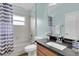 Well-lit bathroom with a shower-tub combo, granite vanity, and a decorative mirror at 1709 Nodding Thistle Dr, New Port Richey, FL 34655