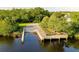 Wooden dock and boat ramp provide easy access to the waterway, surrounded by green trees at 1709 Nodding Thistle Dr, New Port Richey, FL 34655