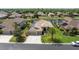 Aerial shot of home showcasing the front lawn, three-car garage, and a serene lake in the backyard at 1709 Nodding Thistle Dr, New Port Richey, FL 34655