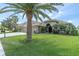 Beautiful home with a well-manicured lawn, mature trees, and a three-car garage at 1709 Nodding Thistle Dr, New Port Richey, FL 34655