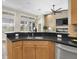 Open concept kitchen with granite countertops, stainless steel appliances, and views of the living area and screened lanai at 1709 Nodding Thistle Dr, New Port Richey, FL 34655