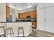 Well-lit kitchen features black countertops, wood cabinets, barstool seating, and stainless steel appliances at 1709 Nodding Thistle Dr, New Port Richey, FL 34655
