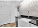 Laundry room with a farmhouse sink and brick accent wall at 1709 Nodding Thistle Dr, New Port Richey, FL 34655