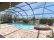 Screened-in pool area with brick paver decking, a spa, and tranquil water views at 1709 Nodding Thistle Dr, New Port Richey, FL 34655