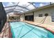 Screened-in pool area with a brick-trimmed pool and a covered pergola seating area at 1709 Nodding Thistle Dr, New Port Richey, FL 34655