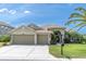 Charming single-story home featuring a three-car garage and a well-manicured front lawn with tropical landscaping at 1709 Nodding Thistle Dr, Trinity, FL 34655