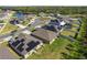 Aerial view of homes in a suburban neighborhood near a lake, with solar panels and green lawns on a sunny day at 1957 Fan Aloe Way, Ruskin, FL 33570