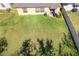 A spacious backyard featuring lush green grass, a well-kept fence, and a house with windows and outdoor equipment at 1957 Fan Aloe Way, Ruskin, FL 33570