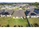 Aerial view of a home backyard with a well-maintained lawn, fence, and nearby neighborhood homes on a sunny day at 1957 Fan Aloe Way, Ruskin, FL 33570