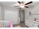 Serene Bedroom design with crib, dresser, closet, butterfly wall decor and neutral tones at 1957 Fan Aloe Way, Ruskin, FL 33570
