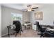 Bright bedroom with a ceiling fan, two desks, vanity and a large window overlooking the yard at 1957 Fan Aloe Way, Ruskin, FL 33570