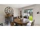 Cozy dining area with a dark wood table, bar cart, and sliding glass doors leading to the backyard at 1957 Fan Aloe Way, Ruskin, FL 33570