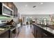 Well-equipped kitchen featuring dark cabinetry, modern appliances, and an open layout leading to the dining area at 1957 Fan Aloe Way, Ruskin, FL 33570