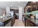 Spacious kitchen featuring modern appliances, dark wood cabinets, granite countertops, and tile flooring at 1957 Fan Aloe Way, Ruskin, FL 33570