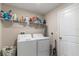 Functional laundry room equipped with washer, dryer, storage shelves, and ample space at 1957 Fan Aloe Way, Ruskin, FL 33570