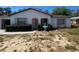 Charming single-story home with red accents, a well-maintained lawn, and an attached one car garage at 2335 Canfield Dr, Spring Hill, FL 34609