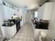 Galley kitchen featuring tiled floors, laminate countertops, and white cabinets at 2335 Canfield Dr, Spring Hill, FL 34609