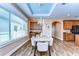 Dining room features wood floors, large window, and a chandelier, open to the kitchenette and entryway at 2506 W Ivy St, Tampa, FL 33607
