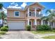Inviting two-story home features a front balcony, brick paver driveway, and lush landscaping at 2506 W Ivy St, Tampa, FL 33607