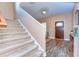Bright foyer with carpeted stairs, hardwood floors, and a wooden front door at 2506 W Ivy St, Tampa, FL 33607
