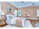 Stylish main bedroom showcasing tray ceiling, wood flooring, and serene decor at 2506 W Ivy St, Tampa, FL 33607