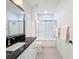 Well-lit bathroom featuring a granite countertop, a sink with a chrome faucet, and a tiled shower with glass door at 2630 Milford Berry Ln, Tampa, FL 33618