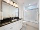 Bright bathroom with sleek vanity, granite countertop, mirror, and a glass-enclosed shower/tub combination for modern living at 2630 Milford Berry Ln, Tampa, FL 33618