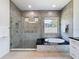 Modern bathroom featuring glass shower and soaking tub with dark countertops at 2630 Milford Berry Ln, Tampa, FL 33618