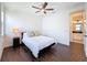 Cozy bedroom with hardwood floors, a ceiling fan, and a glimpse into the adjacent bathroom at 2630 Milford Berry Ln, Tampa, FL 33618