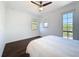 Bright bedroom featuring dark wood floors, two large windows, and ceiling fan with light at 2630 Milford Berry Ln, Tampa, FL 33618