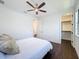 Comfortable bedroom showcasing hardwood floors, a ceiling fan, and an adjacent walk-in closet at 2630 Milford Berry Ln, Tampa, FL 33618