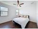 Bright bedroom featuring hardwood floors, a ceiling fan, and two large windows that provide ample natural light at 2630 Milford Berry Ln, Tampa, FL 33618