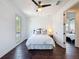 Bright bedroom features dark wood floors, large window, and ceiling fan with light at 2630 Milford Berry Ln, Tampa, FL 33618