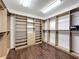 Walk-in closet featuring wood floors and shelving units at 2630 Milford Berry Ln, Tampa, FL 33618