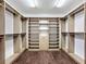Spacious walk-in closet featuring custom wood shelving, hanging rods, and ample storage for an organized wardrobe at 2630 Milford Berry Ln, Tampa, FL 33618